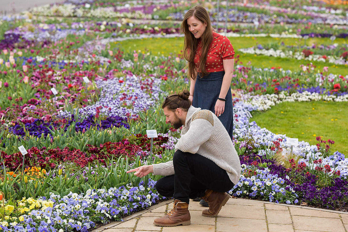 Ein Mann und eine Frau, welche sich ein Blumenbeet ansehen