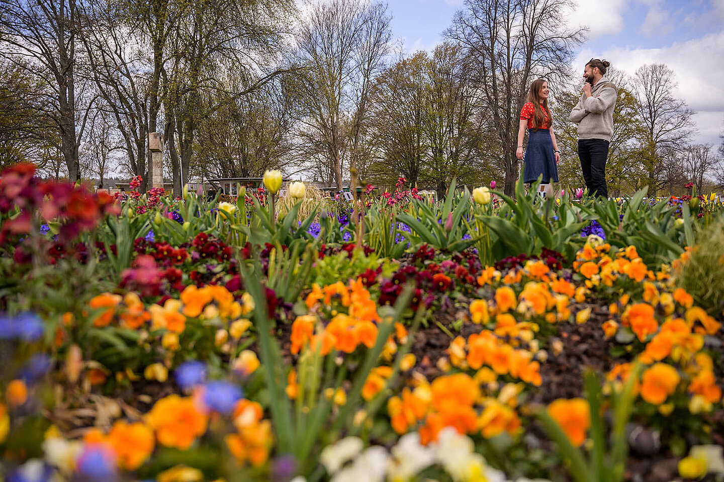 ein Mann und eine Frau, welche sich ein Blumenbeet ansehen