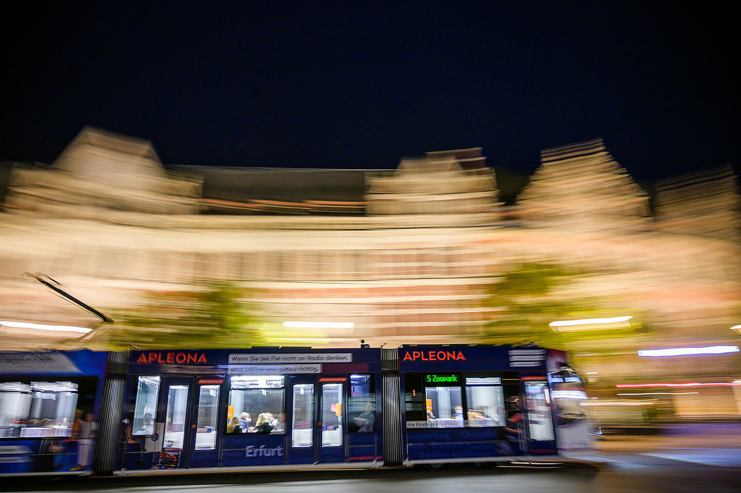 Eine Straßenbahn fährt bei Nacht durch Erfurts Innenstadt