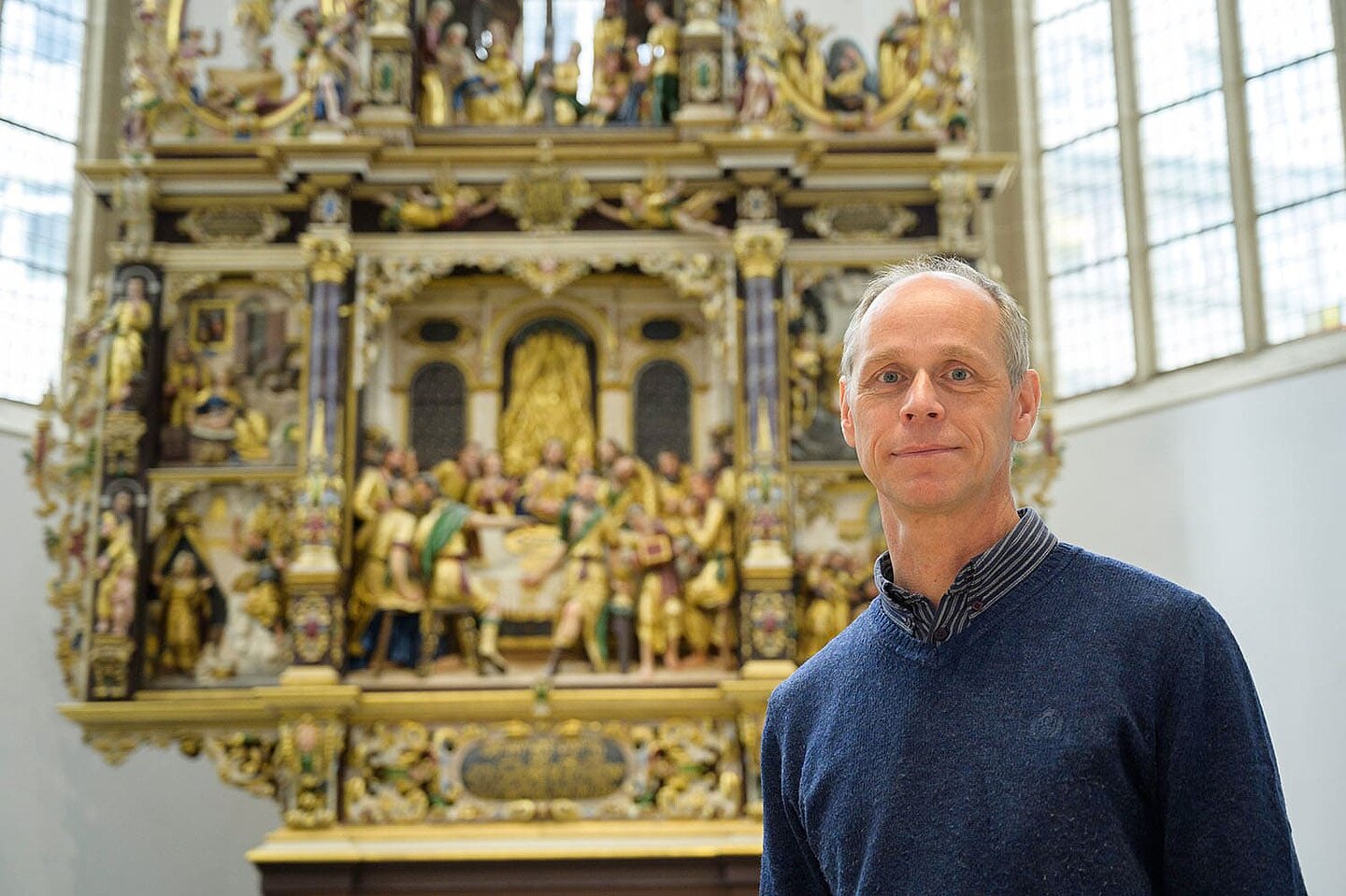  A man standing in front of the altar looks straight into the camera