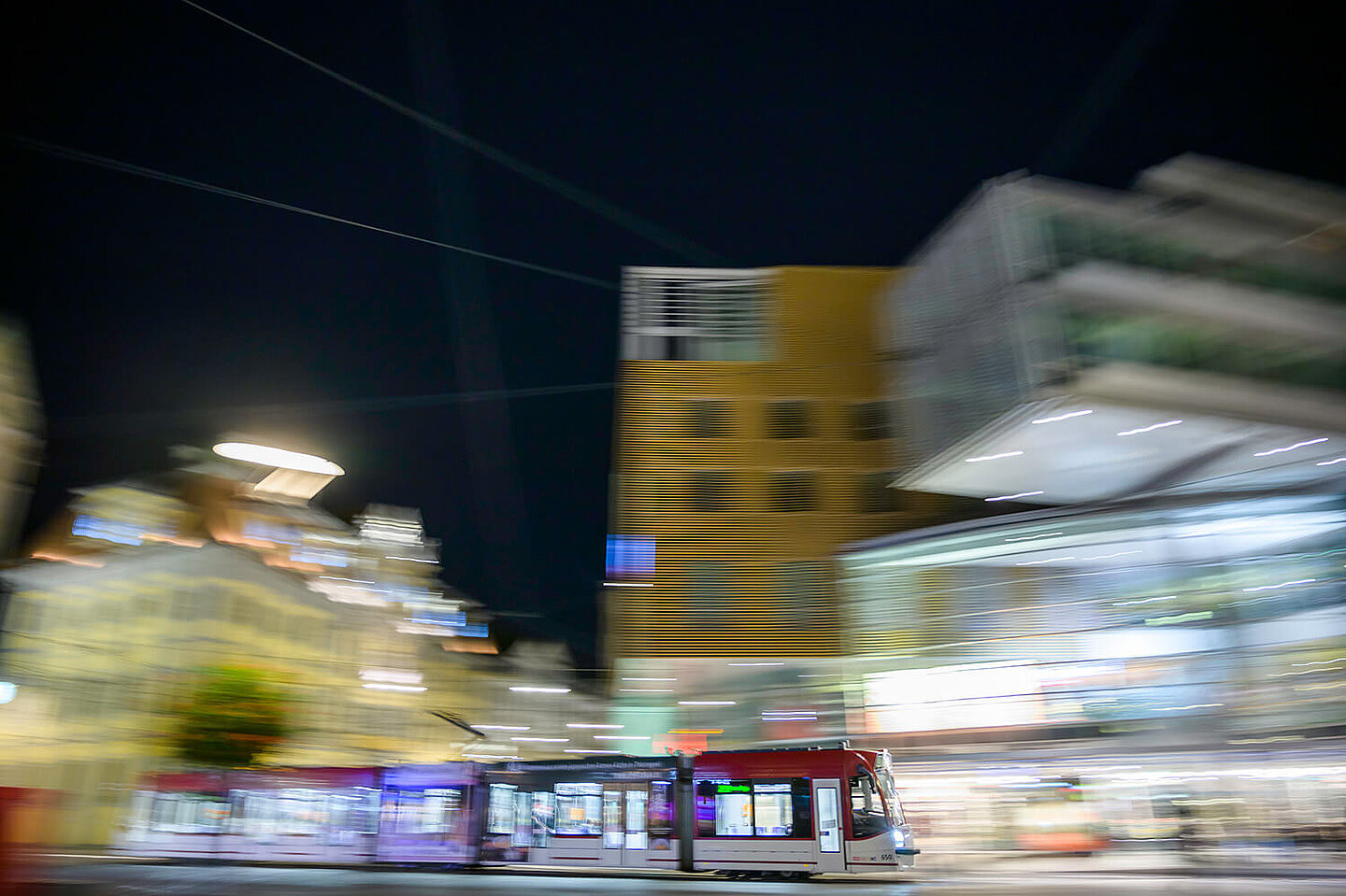 Eine Straßenbahn fährt bei Nacht durch Erfurts Innenstadt