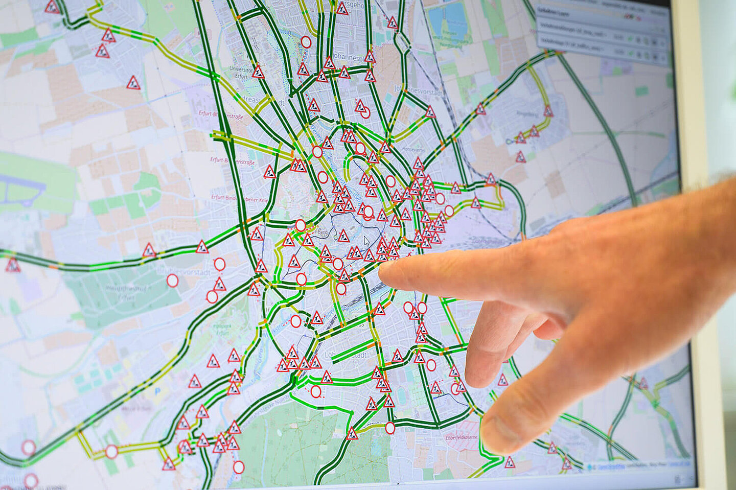 Eine Hand zeigt auf eine Stadtkarte, auf der alle Baustellen angezeigt werden